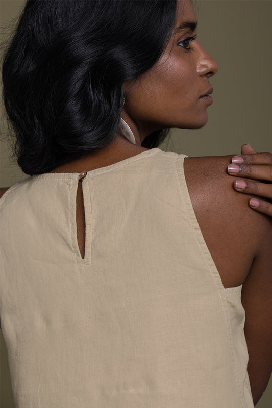 Woman wearing a beige sleeveless top with a plain background Reading Tea Leaves midi dress in neutral beige sustainable hemp with A-line fit, side slits and practical pockets