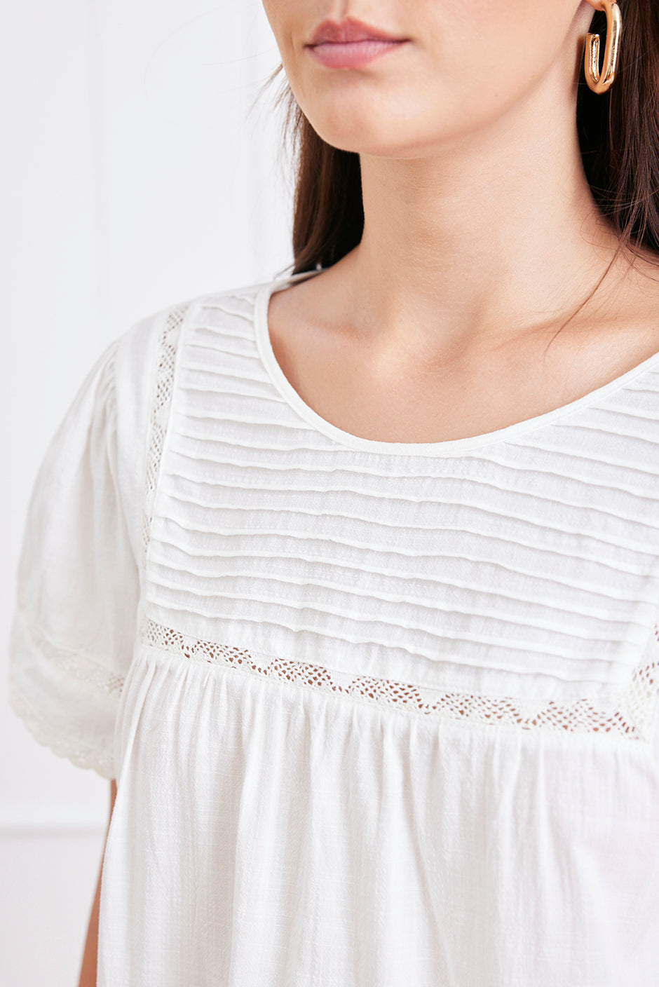 White dress with lace details on a plain background