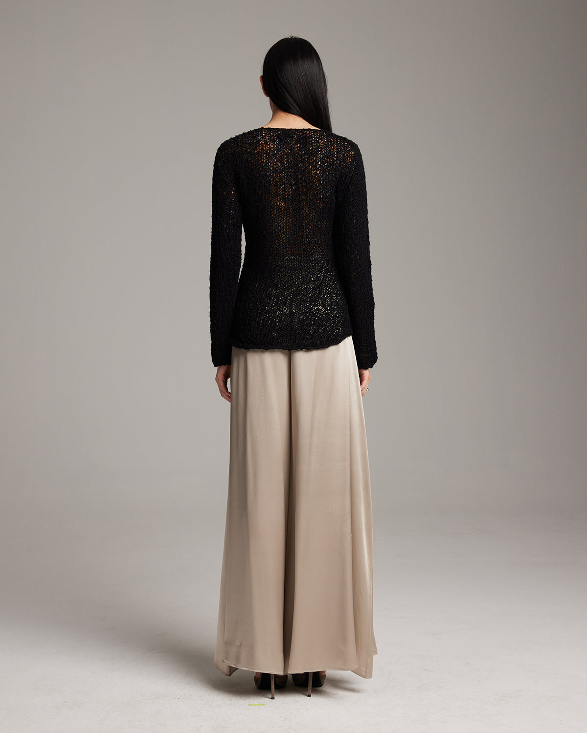 Person wearing a black textured top and beige skirt on a plain background Silk palazzo pants in flowing charmeuse with dramatic wide leg silhouette, ethically made in NYC by VOZ
