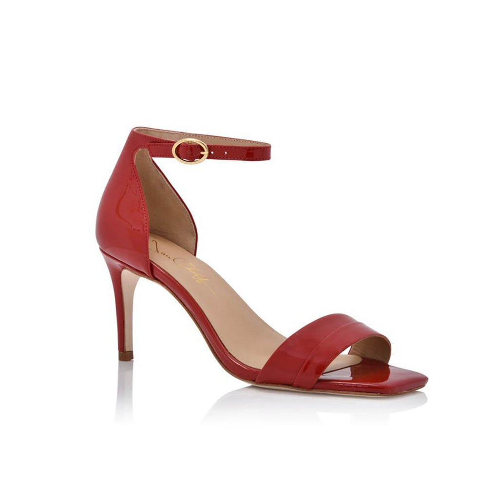 Red high-heeled sandal with a gold buckle on a white background